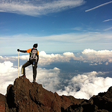 富士山から見下ろす雲海の前で仁王立ち。いかにも登山家のようです。